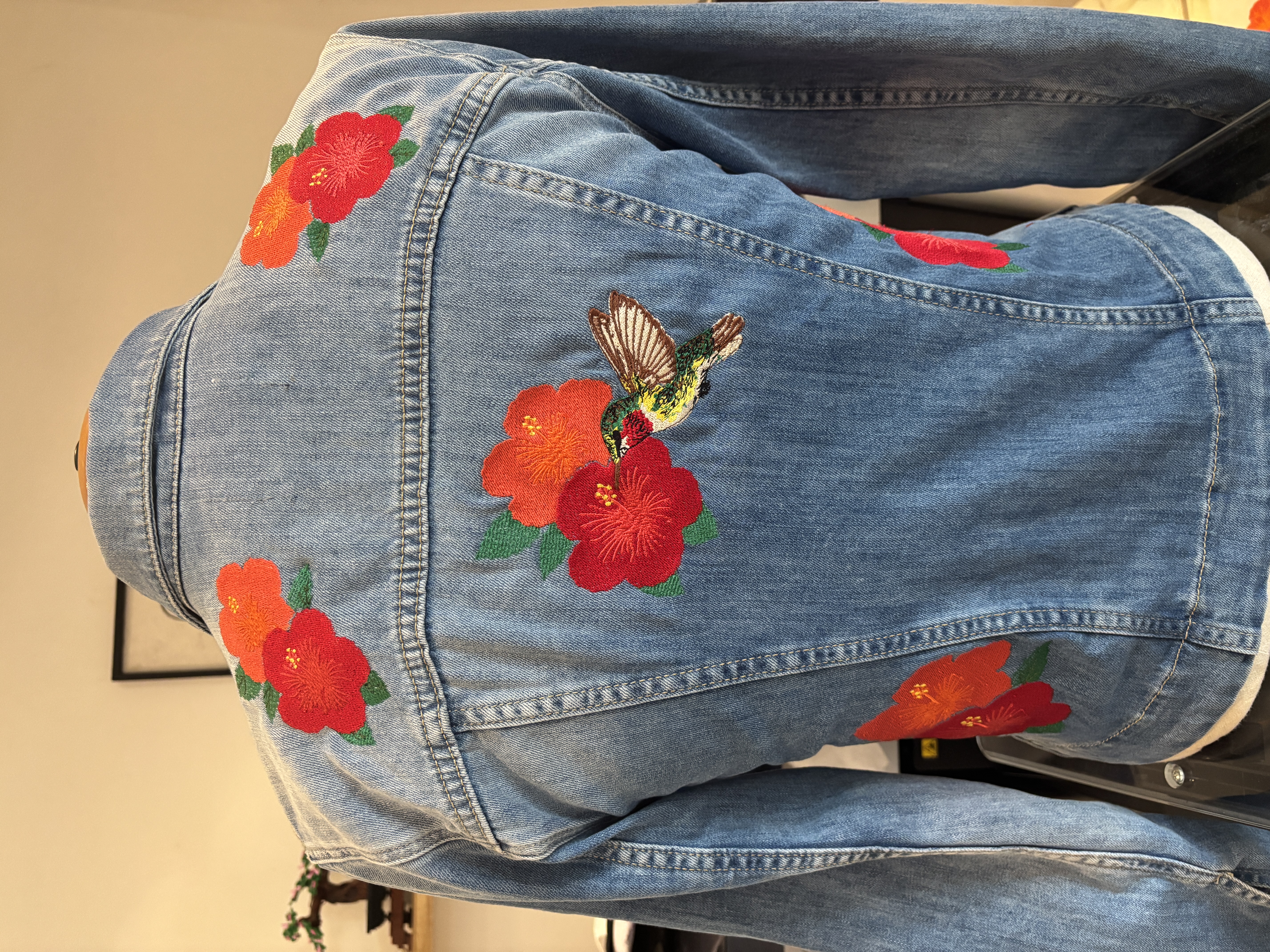 Veste en jean personnalisée avec broderie florale et colibri réalisée par Happening So en Seine-et-Marne